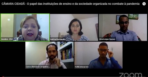 Imagem de uma tela computador com o rosto de cinco participantes discutindo sobre a importância das Instituições de ensino no combate à Covid-19