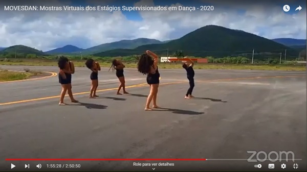 Apresentação de dança que integrou as Mostras Virtuais dos Estágios Supervisionados em Dança - 2020, realizada em dezembro do ano passado. Na imagem, em uma estrada asfaltada há cinco mulheres em performance de dança, trajando roupas pretas.