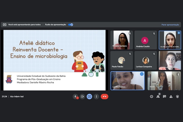 Captura de tela de reunião na plataforma Google Meet. Em destaque, apresentação com o nome “Ateliê Didático Reinventa Docente - Ensino da Microbiologia”. Aparecem também diversas imagens de participantes da reunião.